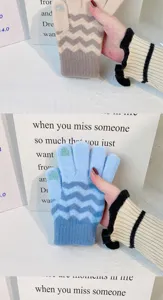 Close-up of women's winter knit gloves featuring contrast wave patterns and touch screen fingertips.