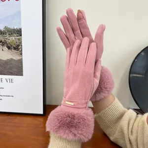 Close-up detail of winter warm touch-screen gloves in pink with soft faux fur cuffs cozy desk.