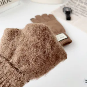 Close-up detail of winter warm knitted touch screen gloves with cozy plush texture and patch.