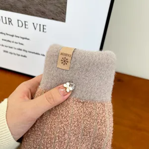 Close-up detail shot of a winter thick fleece knitted mitten glove with cute fashion label.