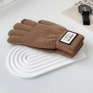 Detailed view of men's winter warm knit touchscreen gloves in brown with stylish text patch.