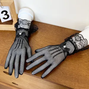 Detailed view of women black lace fishnet gloves with bow, elegant short mesh design for summer.