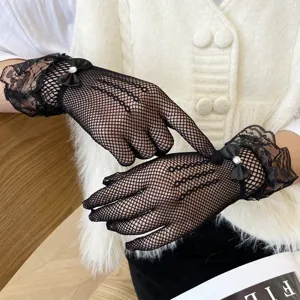 Detailed close-up of black lace fishnet gloves featuring a cute bow and rhinestone accent.