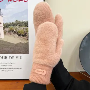 Closeup of cozy winter plush mittens, soft fluffy faux mink material in warm pink for cold days.