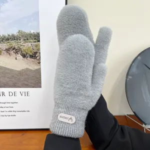 Close-up detail of soft fluffy grey winter mittens, cozy plush texture and ribbed cuff design.