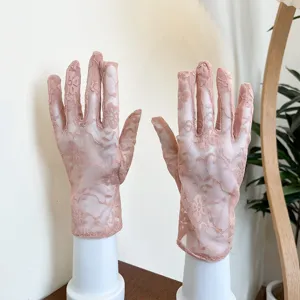 Détail de gants de protection solaire en dentelle rose, design court en maille respirante été.