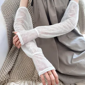 Closeup of white floral lace sun protection sleeves, breathable arm covers for summer.