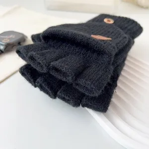 Close-up detail of black knitted convertible fingerless gloves with flip top and button design.