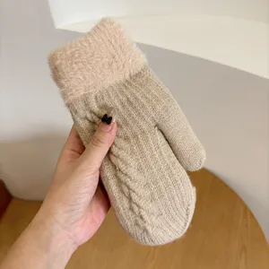 Close-up view of a cozy winter knit mitten, showing soft plush cuff and cable texture detail.