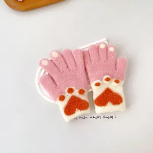 Detailed view of children's cute pink knitted gloves with warm cat paw heart jacquard design.
