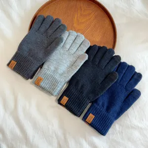Detailed view of winter knitted touchscreen gloves in multi-colors neatly arranged on tray.