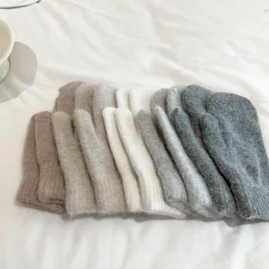 Detailed shot of cozy plush winter mittens in various colors, soft and warm fleece-lined design.