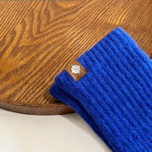 Solid color blue knit winter warm gloves detail shot, cozy woolen thermal accessory for women.