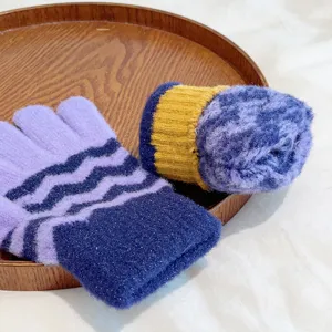 Detail view of winter warm knit gloves featuring wave stripes, shiny threads and soft texture.