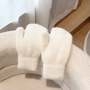 Cozy white fluffy knit mittens detail, soft warm winter plush gloves close-up view