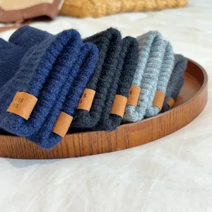 Detailed view of winter knitted gloves for men, featuring soft warm fabric and stylish leather tags.