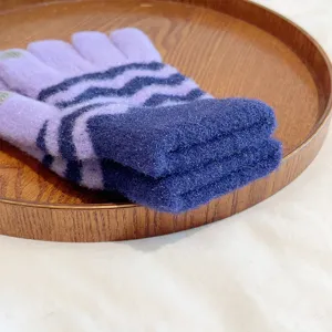 Knit glove detail shot showcasing purple wave stripe winter warm touch screen fabric.