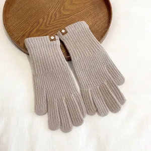 Detailed shot of solid color knit warm gloves, soft winter texture and cute leather patch.