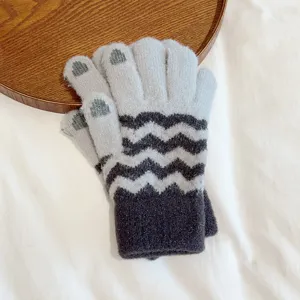 Close-up detail of warm winter knit gloves with cute paw print and stylish wave stripe design.