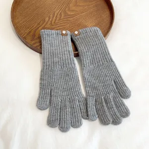 Detailed view of grey knitted warm winter gloves, soft texture and comfortable fit.