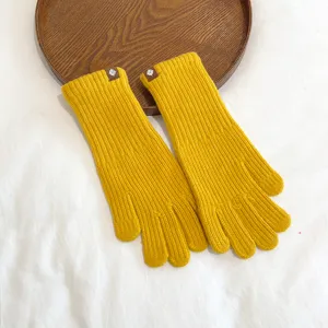 Close-up detail view of cozy yellow knit winter gloves, showing soft thermal fabric texture and cuff.