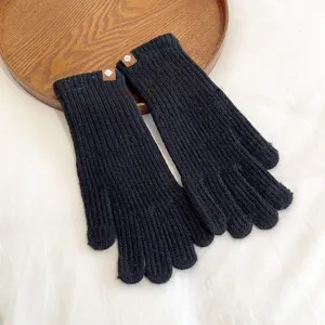 Close-up detail of black knitted winter gloves, showing ribbed texture and soft warm fabric.