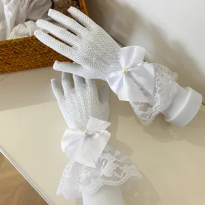 White lace fishnet gloves with satin bow and pearl detail, elegant spring summer accessory.