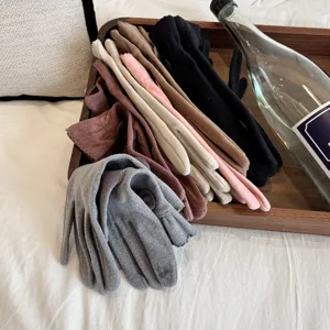 Close-up of cozy multi-color fleece thermal gloves neatly arranged on a wooden tray.