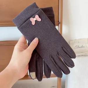 Close-up of women's thermal fleece gloves featuring a cute pink bow detail, soft texture.
