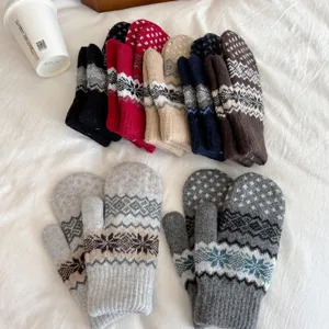 Close-up detail of winter knit mittens with classic Nordic snowflake pattern, cozy and warm.