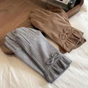 Detail view of women thermal fleece gloves with bow and ruffle cuff for winter outdoor.