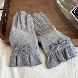 Women's grey thermal gloves featuring elegant bowknot and ruffled cuffs. Detail view.