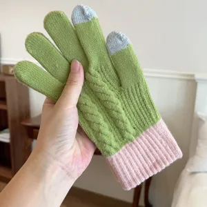 Nahaufname von grunem und rosafarbenem Strickhandschuh mit Zopfmuster und praktischer Touch-Funktion.