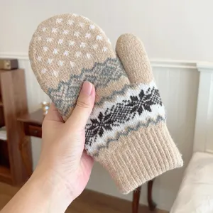 Detail shot of thick warm winter knitted mittens with classic snowflake and mountain Nordic patterns.