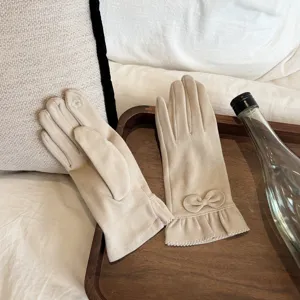 Women thermal velvet gloves detail, chic bow and lace trim design, cozy winter wear closeup.