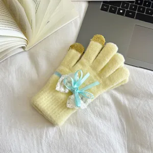 Detail view of winter warm knitted touchscreen gloves with cute blue lace bow decoration.
