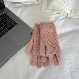 Detailed view of pink winter knitted gloves with hollow out touch screen design, cozy texture.
