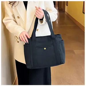 Detailansicht der schwarzen Segeltuchtasche mit doppelten Henkeln und praktischer Fronttasche.
