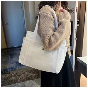 Detailansicht der weißen Canvas Schultertasche mit großer Kapazität und Seitentaschen.
