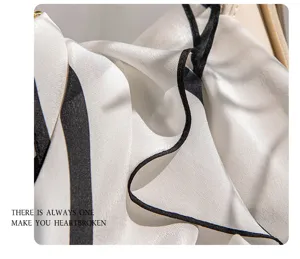 Close-up view of the smooth mulberry silk scarf showing exquisite black and white striped detail.