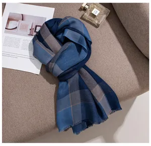 Detailed view of the elegant blue grey plaid cashmere scarf in lifestyle setting.