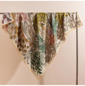 Elegant floral silk wool square scarf featuring vibrant botanical print and yellow rolled edge.