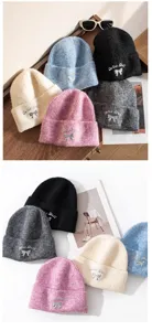 Close-up shot of soft knit winter beanies with metallic bow embroidery and multiple color options.
