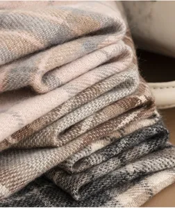 Close-up detail of women winter plaid scarf showing soft fabric texture and warm fold design.