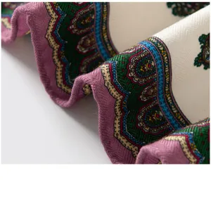 Close-up detail of the elegant double-sided paisley printed scarf, showing fine texture.