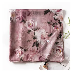 Detailed view of a pink mulberry silk scarf featuring an elegant rose print design.