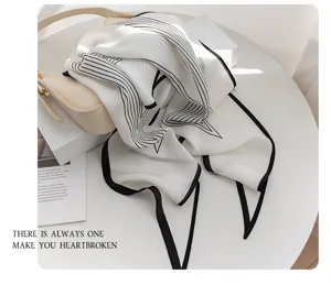 Exquisite detail of the women's mulberry silk scarf featuring elegant black and white stripes.