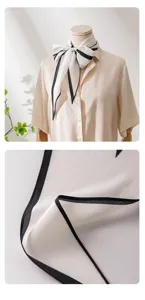 Silk scarf detail close up showing exquisite black border stitching and soft fabric texture.