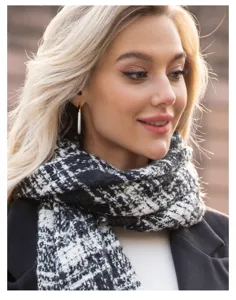 Close-up detail view of the classic black and white houndstooth plaid winter scarf.