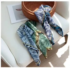 Vue détaillée d'un carré de foulard en soie et laine aux motifs géométriques élégants.